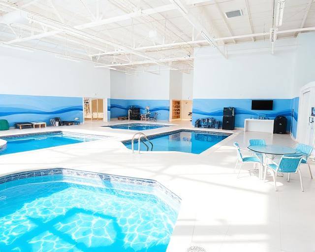 Showroom amplo e claro com várias piscinas expostas e mesa de apoio
